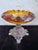 This elegant antique compote features a thick amber glass bowl with a sculptural scalloped rim, resting on an ornate cast...
