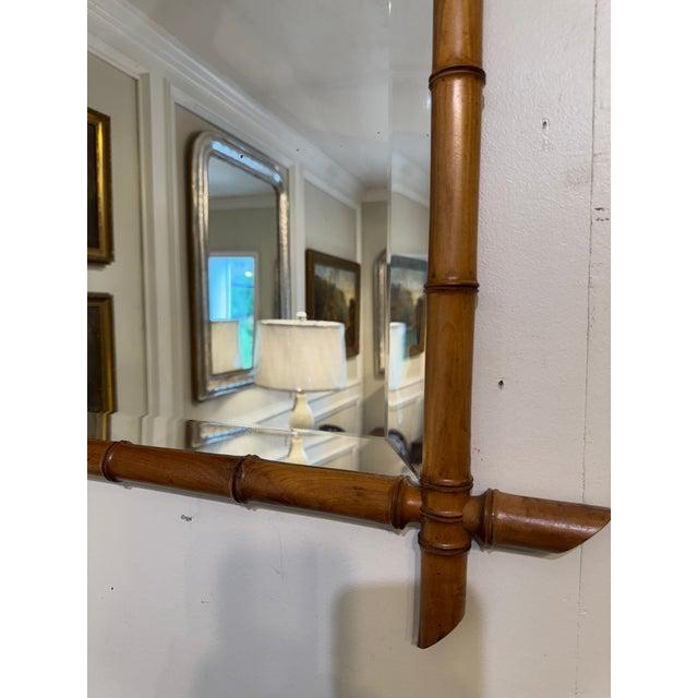 This is a French antique faux-bamboo wall mirror with a beveled glass and hand-carved wood frame. The frame is wood that...