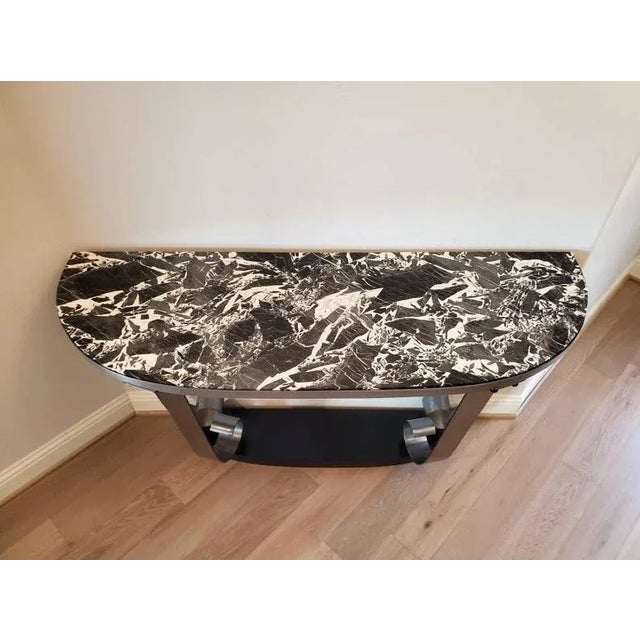 A large and impressive, circa 1930s, Art Deco scrolled steel marble-top demilune console table, attributed to iconic...