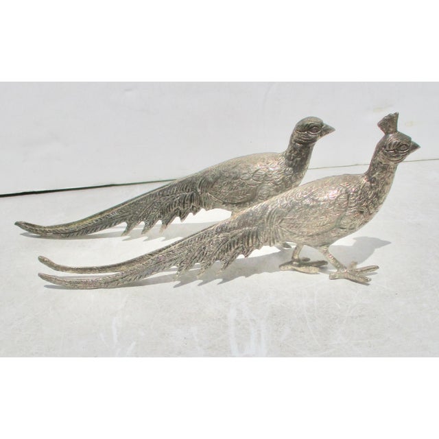 A matched pair of male and female pheasants. Silvered bronze birds made to ornament the shelf of a table— early mid-...