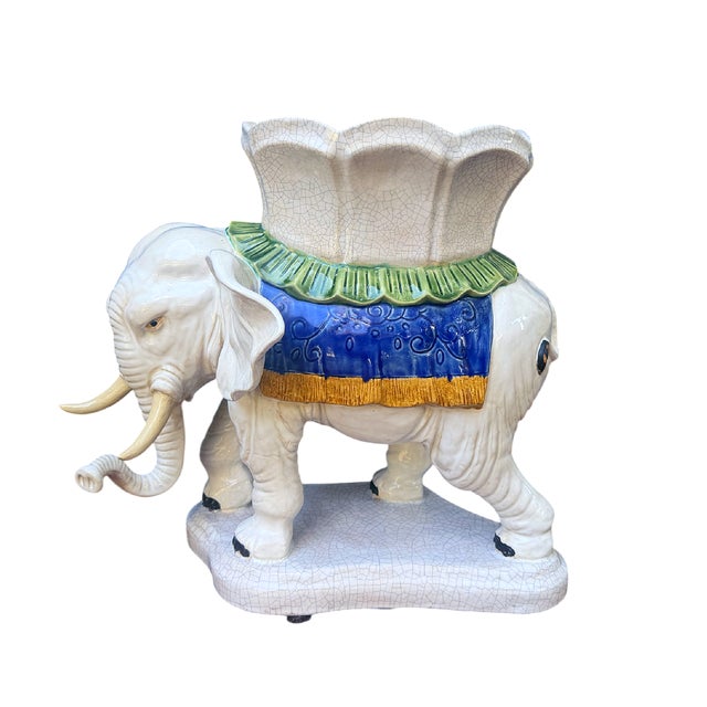 This is a vintage whimsical Palm Beach Style ceramic elephant plant stand. This charming elephant features a cream-colored...
