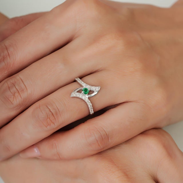 The Eye Motif Natural Emerald & Diamond Pavé Set Crossover Cocktail Ring is a sophisticated statement piece crafted in 925...