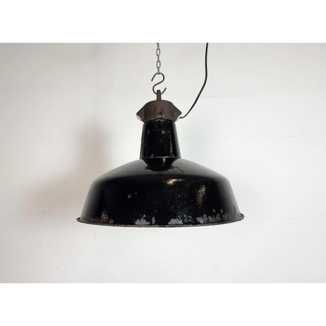 Industrial black enamel pendant light made by Elektrosvit in former Czechoslovakia during the 1950s. White enamel inside...
