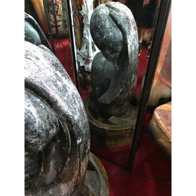 I believe concrete with a granite look when wet it comes in 2 parts the base and the top stylized mother and child with a...