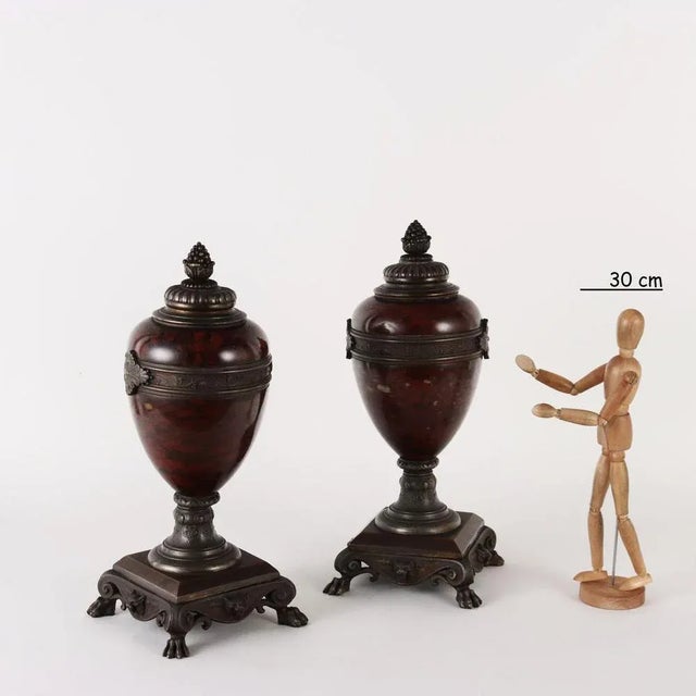 Pair of Rouge Griotte marble vases mounted on bronze patinated metal. Decorations with plant and zoomorphic motifs; feet...