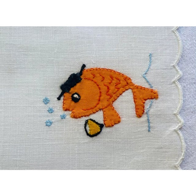 This is a set of 4 mid century vintage linen appliqué and embroidered cocktail napkins featuring multicolor fish drinking...