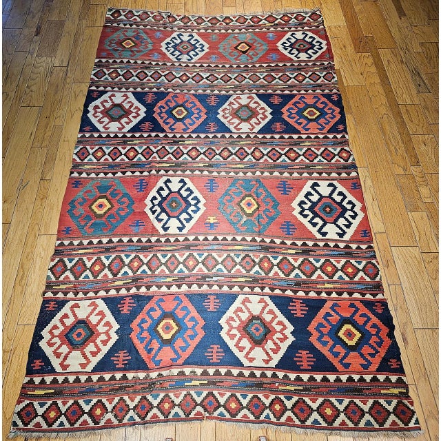 Step into the world of authentic tribal artistry with this exceptional 19th century Caucasian Kazak room size kilim....
