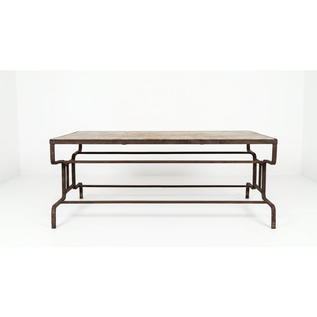 Large artisan coffee table produced in France during the early 20th century. Hand-forged wrought iron base paired with a...