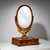 Biedermeier table mirror with a drawer and a tilting oval mirror plate supported by a carved, partially gilt eagle. The...
