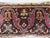 This is a pillow upholstered in a 19th century rug fragment, featuring charming tribal motifs. There is wear on some areas.