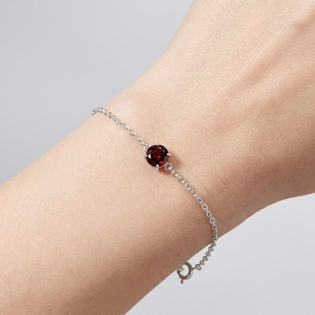 Elegant in its simplicity, this refined bracelet features a striking deep red gemstone delicately set on a fine silver...