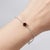 Elegant in its simplicity, this refined bracelet features a striking deep red gemstone delicately set on a fine silver...