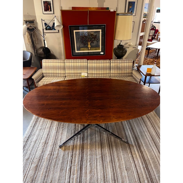 A striking vintage rosewood dining table by Knoll International, featuring a beautifully proportioned oval top supported...