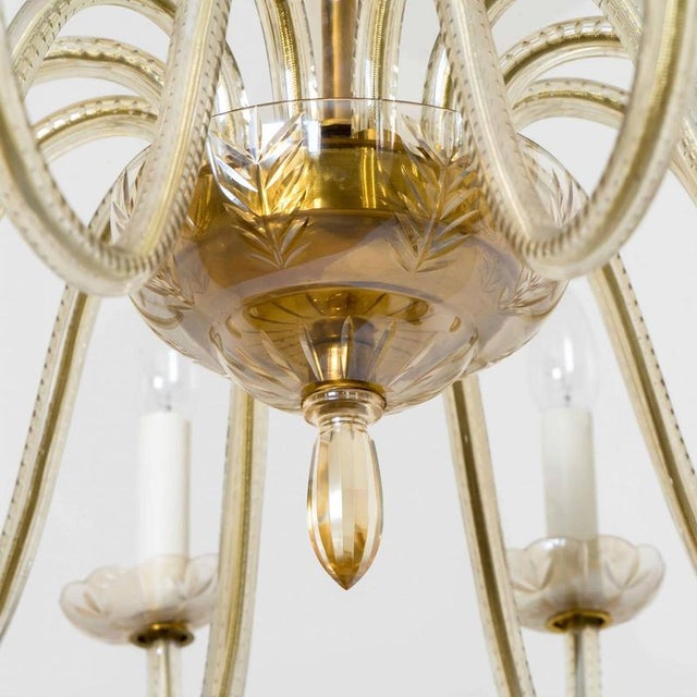 Beautiful 12 arms murano glass chandelier, italy 1960. The warm amber glass exudes a rich, inviting glow, while the...