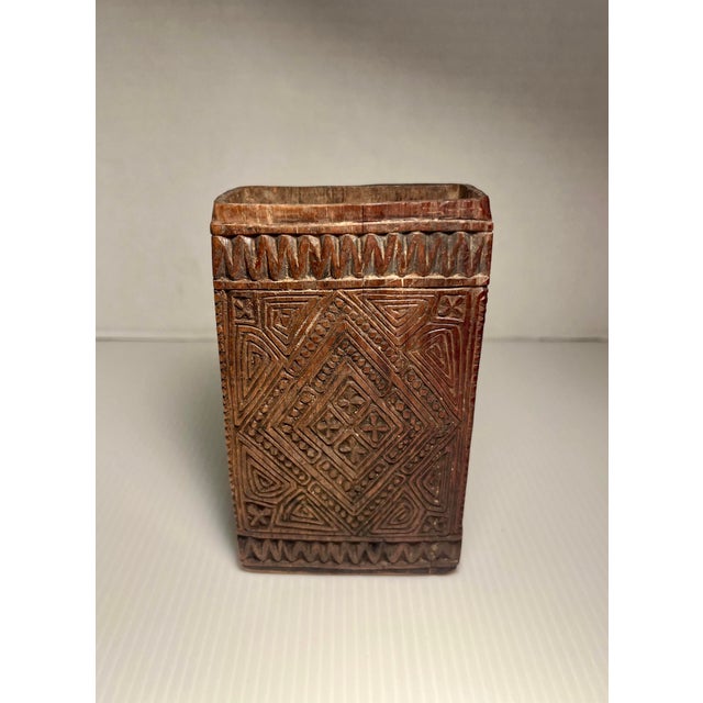 Attributed to the Kuba peoples of the Democratic Republic of the Congo, this unusual small carved wooden container...