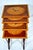 A 20th century sheraton style nest of tables in mahogany with satinwood crossbanding, and hand painted musical...
