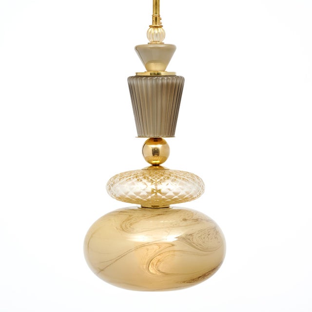 Pair of Murano glass pendants in the style of Ettore Sottsass. This pair includes hand-blown glass elements in a variety...