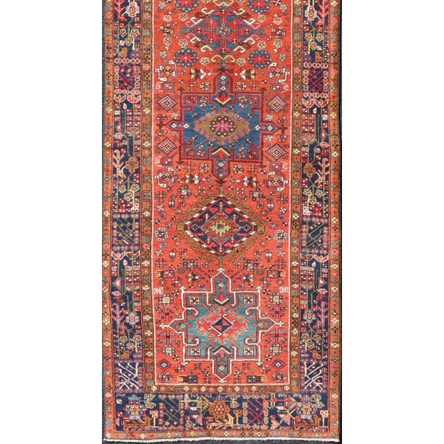 Very Long antique Persian Heriz runner with geometric medallion design in red, blue and colorful tones. Keivan Woven Arts...