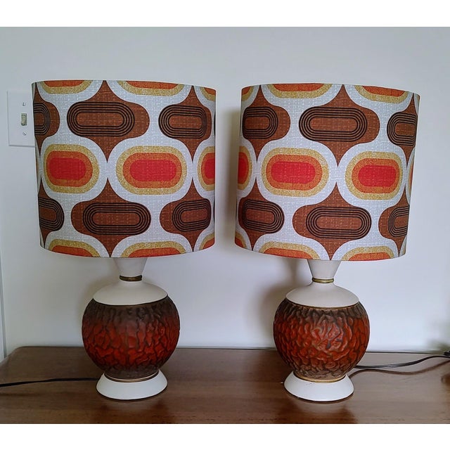 Mid-century modern (MCM) era table lamps, likely from the 1950's or 60's. The lamps feature a sculptural ceramic base with...