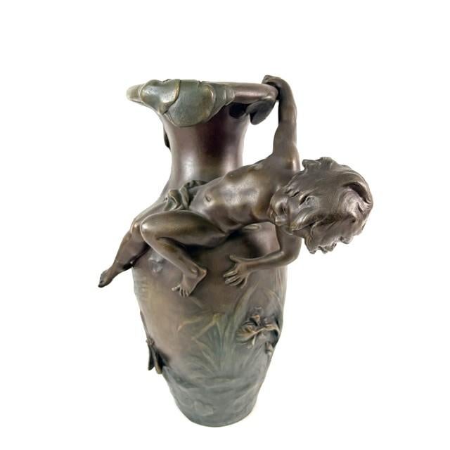 An exceptional French Art Nouveau figural patinated solid bronze vase featuring a beautifully sculpted, playful nude boy...