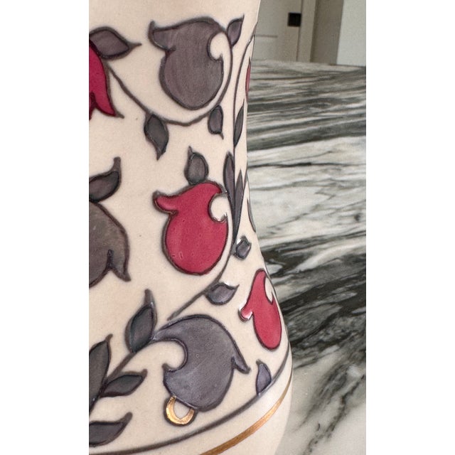 A unique raspberry pink and gray iridescent finish with gold accents adorn this vase in a floral repeat called the Oyster...
