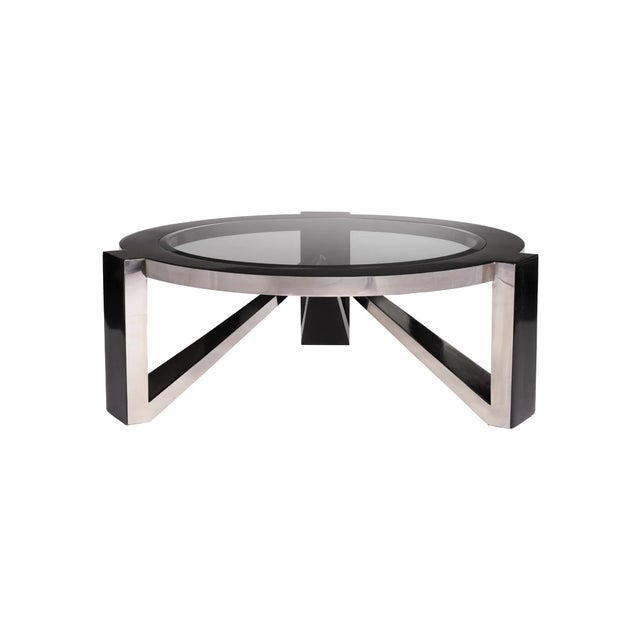 The Triton Cocktail Table pairs black fossil stone with stainless steel to create a striking architectural center for...
