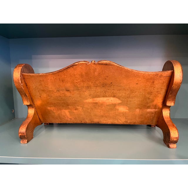 This decadent piece features high-relief floral carvings, scrolling volutes, and a distinct combination of gold gilding...