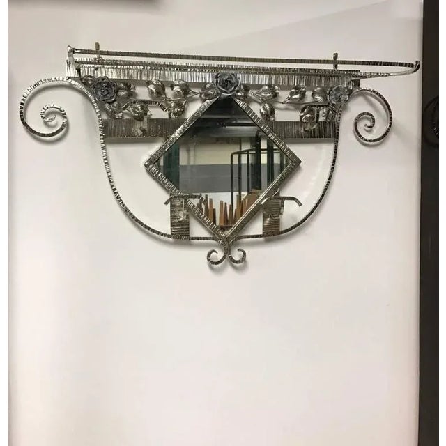 This amazing French Art Deco coat rack with central mirror and hat rack has beautiful details including floral design...