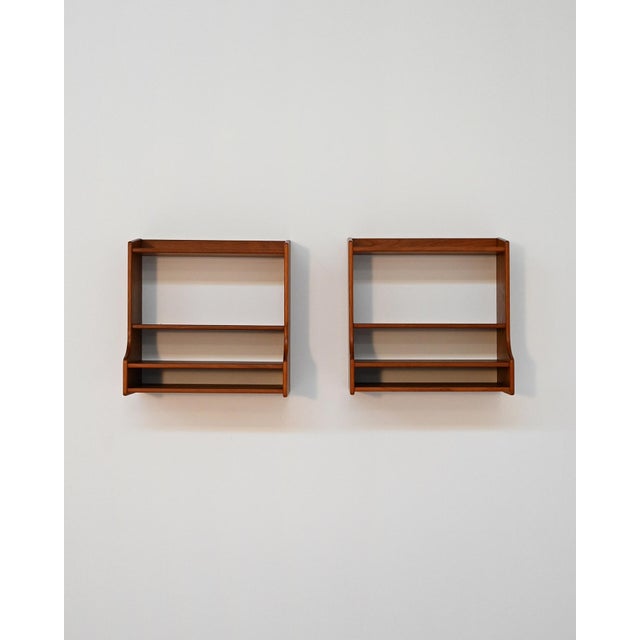 Set of two wall-mounted teak bedside tables with double shelf and lower compartment. Scandinavian production, 1960s. Pair...