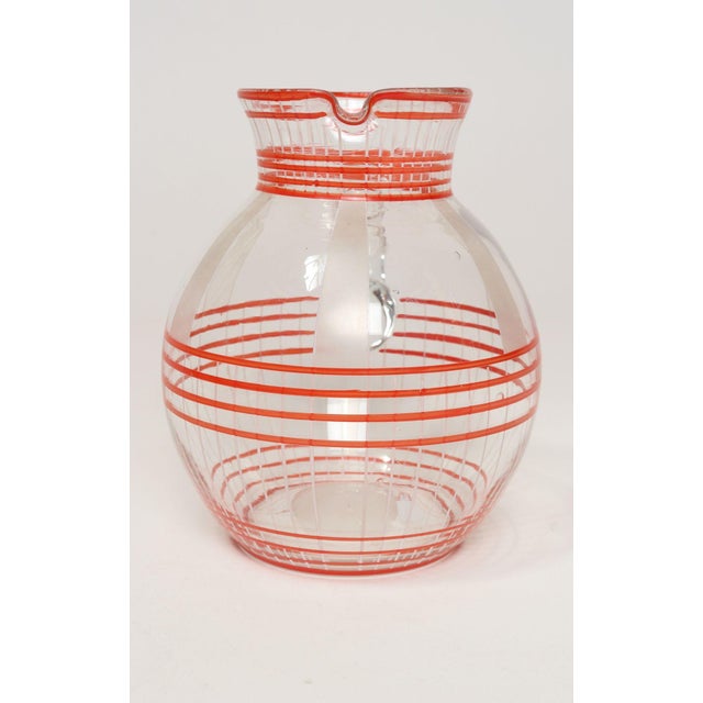 Vintage Art Deco bulbous-form pitcher in blown glass with sculptural handle and red stripe motif (ca. 1940s, USA). There...