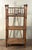 This vintage c.1940's bamboo etagere features three woven wrapped shelves supported by a bamboo frame with turned post...
