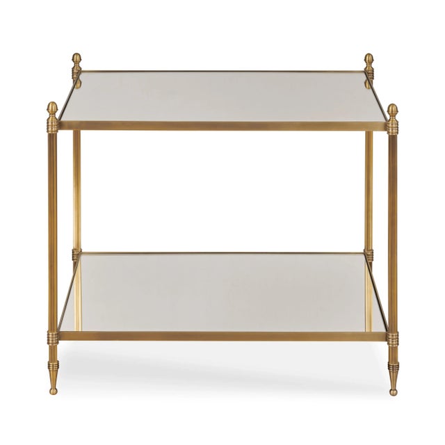 Odesa is an elegant chairside table made from antique brass with a mirrored top and lower shelf. The delicately scaled...
