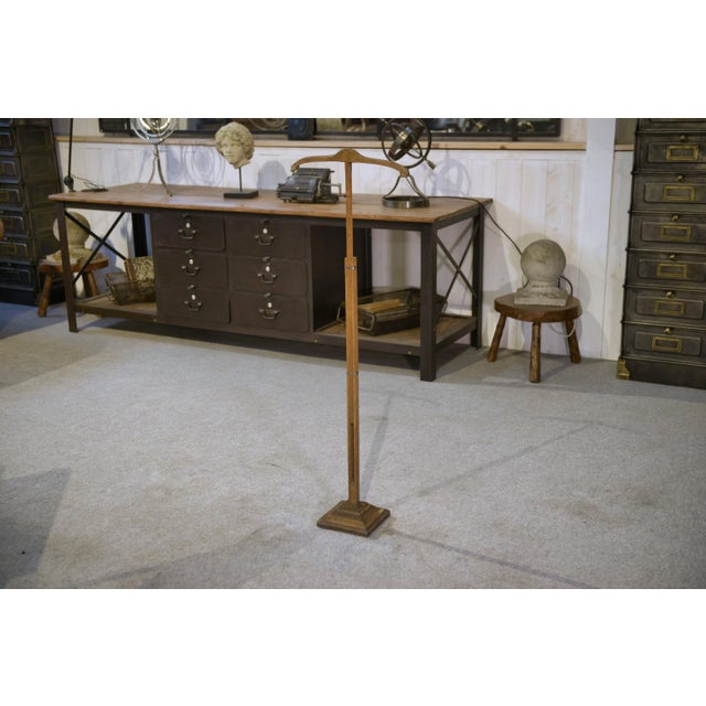 Antique wooden dressmaker's rack with a hanger-shaped top for displaying jackets, blouses, or dresses during fittings. The...