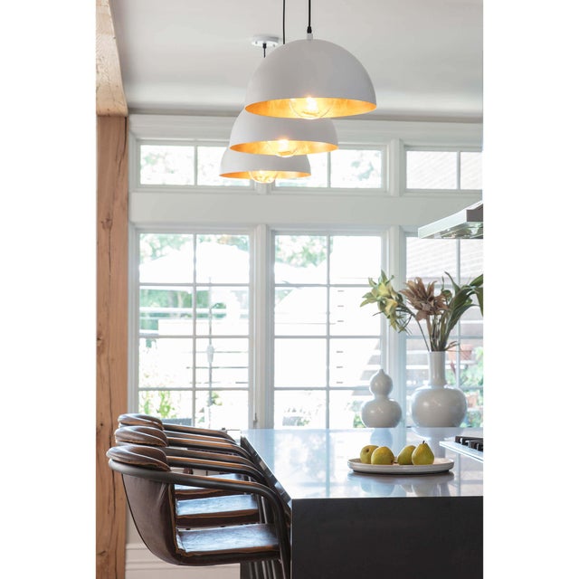 A simple dome shade brings sleek minimalism to the mix. Featuring a gold-leafed finish on the shade’s interior, this gives...