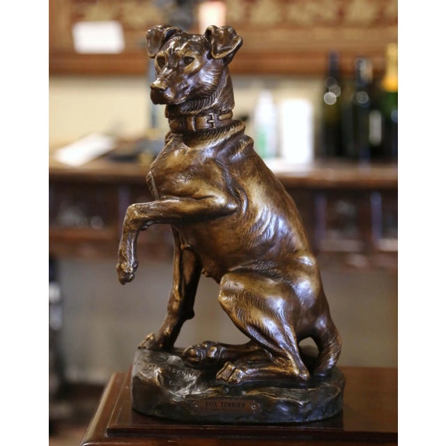This charming antique fox terrier sculpture captures the alert expression and spirited personality of the beloved hunting...