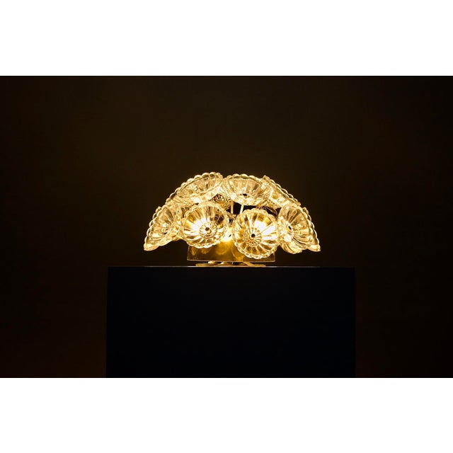 Ceiling or wall light adorned with brass arms, each supporting a clear glass flower, nicknamed "Dandelion" due to its...