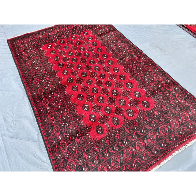 This hand-knotted Khal Mohammadi rug features two columns of small octagonal guls floating in an open crimson field,...