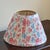 A charming circa 1990 pleated cotton lampshade with a soft floral print over a white backdrop. This shade is equipped with...
