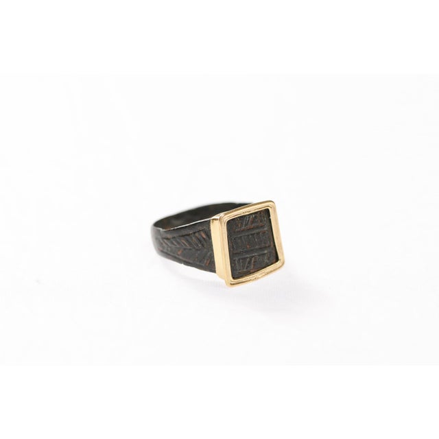 A Byzantine bronze ring with dynamic diagonal line patterns and square edge accent. This bronze coin was minted between...