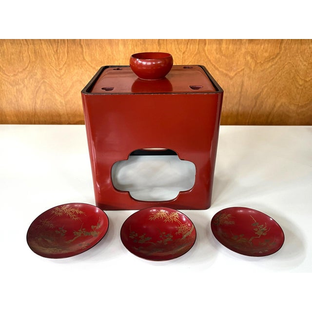 A Japanese lacquered Sake Drinking set circa late 19th century (end of Meiji period), The assemble consists of a red...