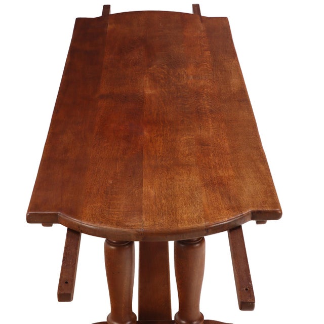 featuring a thick shaped slab top raised on four substantial turned legs joined by a long medial stretcher. Executed in...