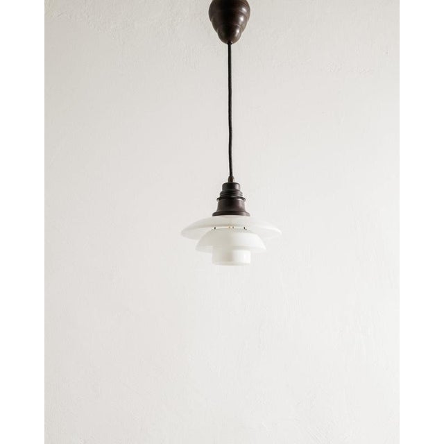 Early danish mid century adjustable ceiling "ph 2/2" pendant in brown bakelite with a complete set of white opaline glass...