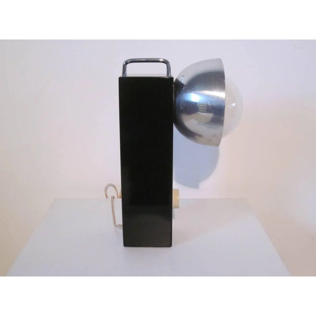 A Mod styled table lamp with black lacquered solid wood base, chrome handle to the top, large rounded bowl styled aluminum...