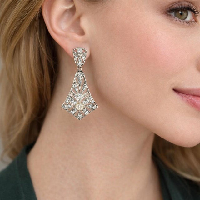 A refined pair of vintage platinum diamond drop earrings dating to the 1940s, designed in an elegant geometric composition...