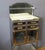 A dentist's cabinet in brushed, chromed, and gilded metal, featuring four drawers and two doors. The shelves are glass,...