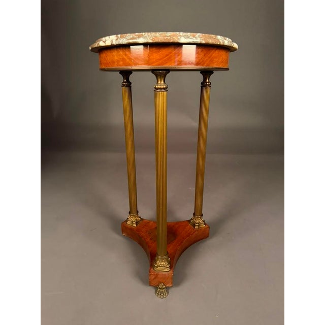 An elegant Italian neoclassical marble-top lamp table showcasing classical architectural influences and exceptional...