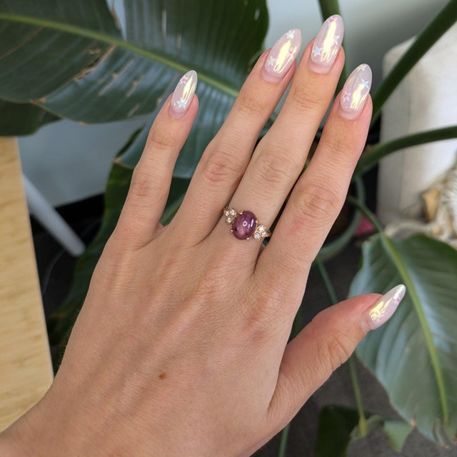 A rich red star ruby cabochon reveals a shimmering six-rayed star across its dome in this striking ring, accented with...