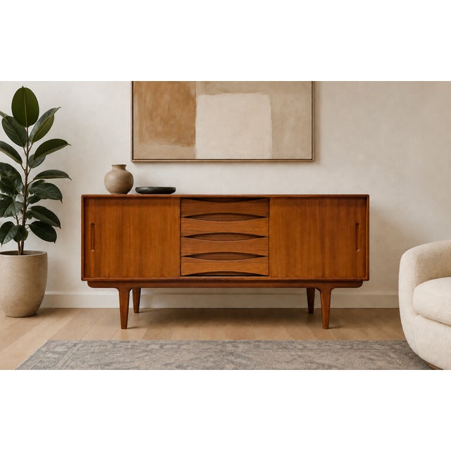 Stunning Mid Century Modern teak credenza handcrafted in Scandinavian style. This timeless piece features a sleek,...