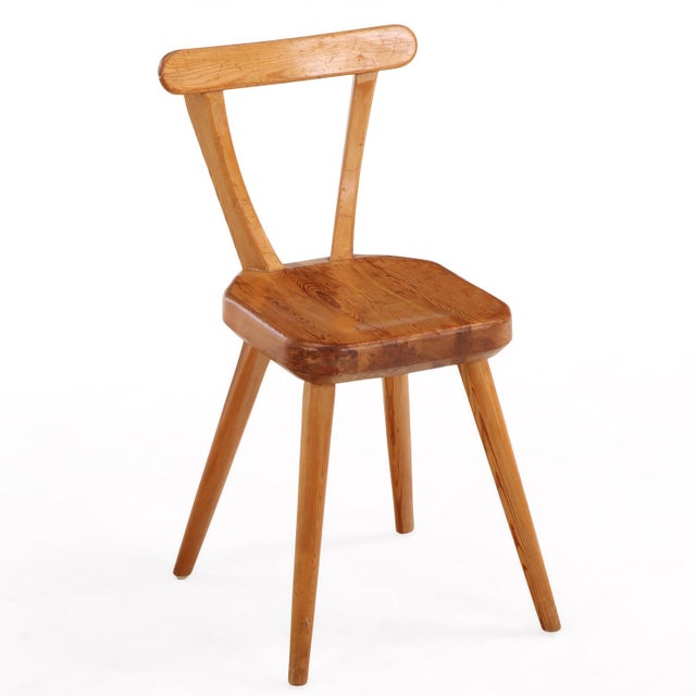 Set of four Swedish pine dining chairs, circa 1940s, featuring curved backrests, twin vertical splats, and tapered splayed...