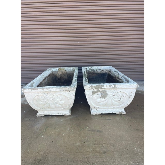 Overview A pair of early 20th-century rectangular cast stone (concrete) garden planters or troughs, salvaged from a...